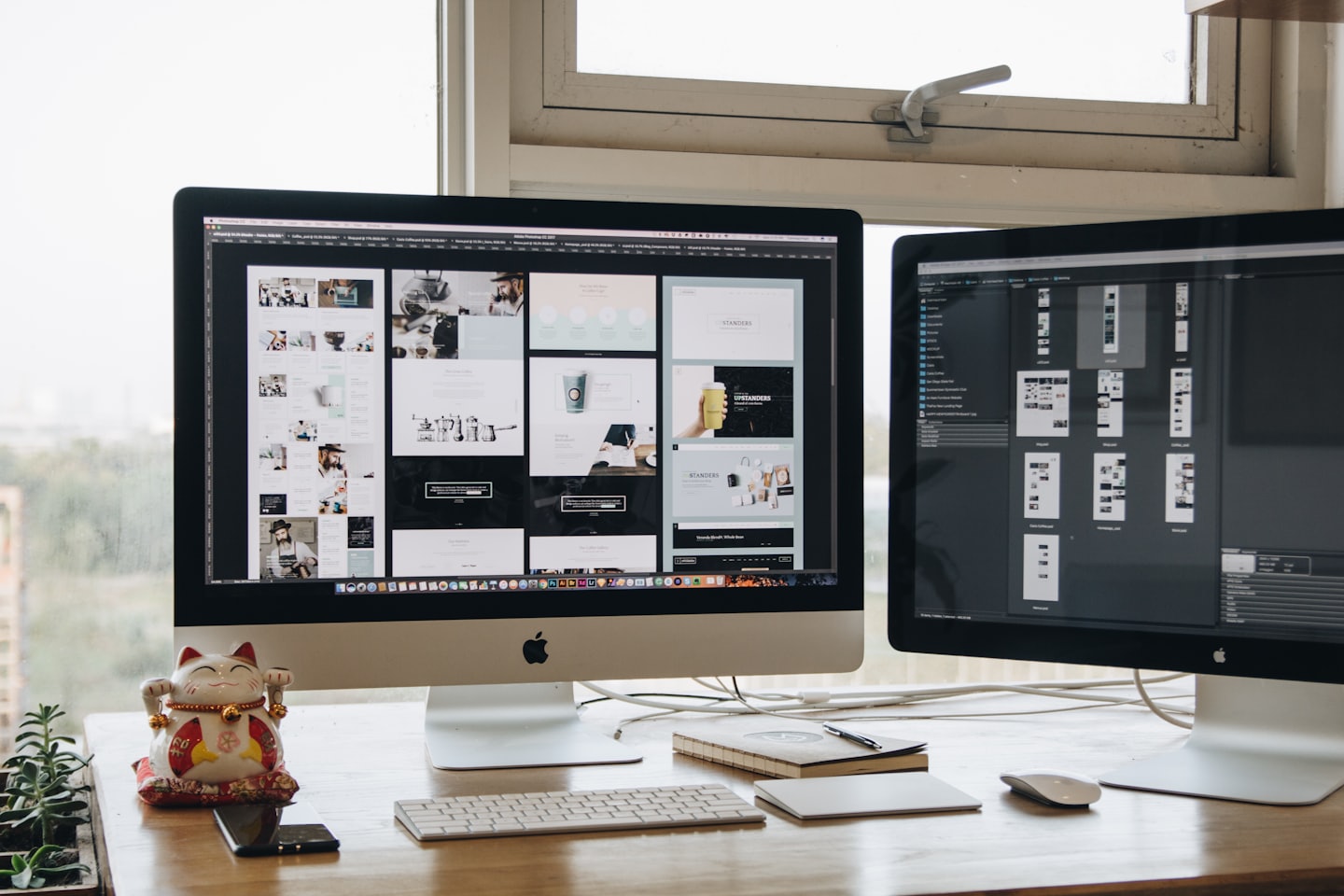 two computer screens in front of a window with keyboard and mouse