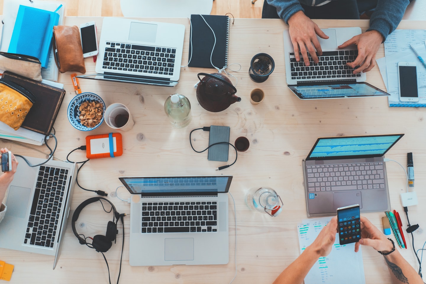 top down image of many people and laptops at a table